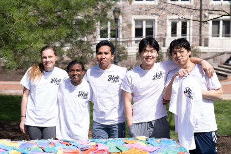 A group photo of 纸飞机外国软件叫什么
 students wearing 'Holi 2024' shirts.